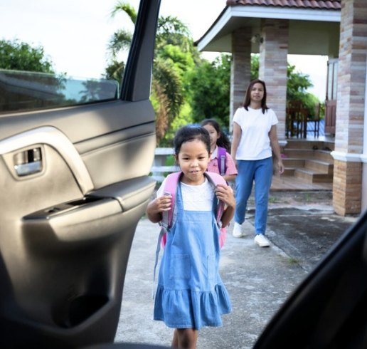 Smiling student walking to the car at morning pickup